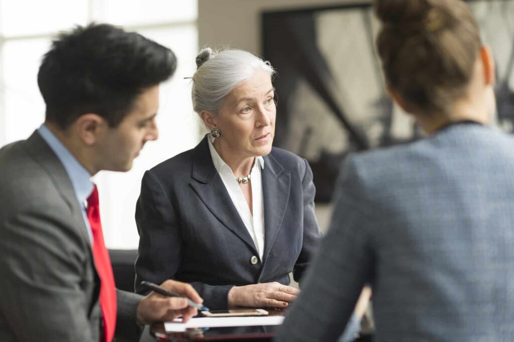 Businessman discussing with female colleagues in boardroom meeting